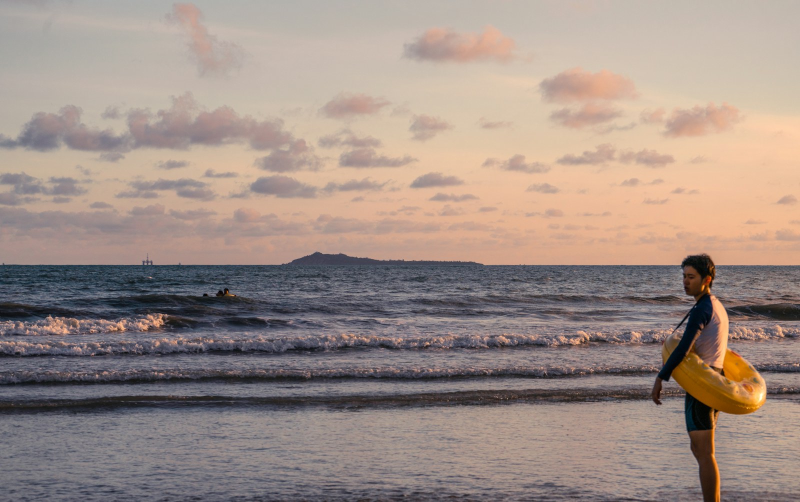 Traveler walking along a quiet beach at sunset